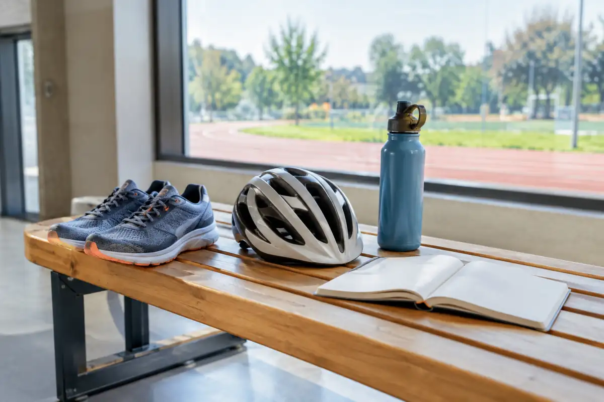 Chaussures de course, casque de vélo et carnet réunis pour illustrer la comparaison de plusieurs sports.
