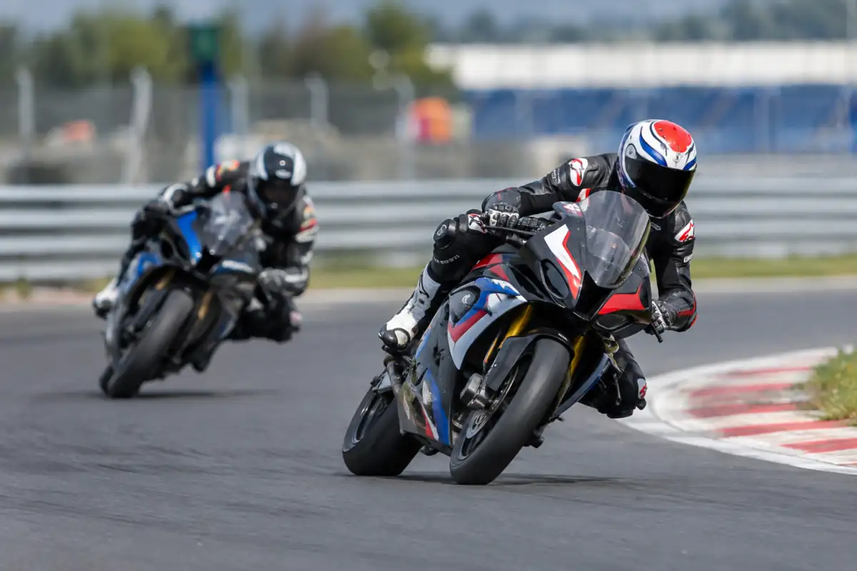 Deux pilotes en combinaison cuir négocient un virage sur des motos de course dérivées de modèles routiers en Championnat du monde Superbike.