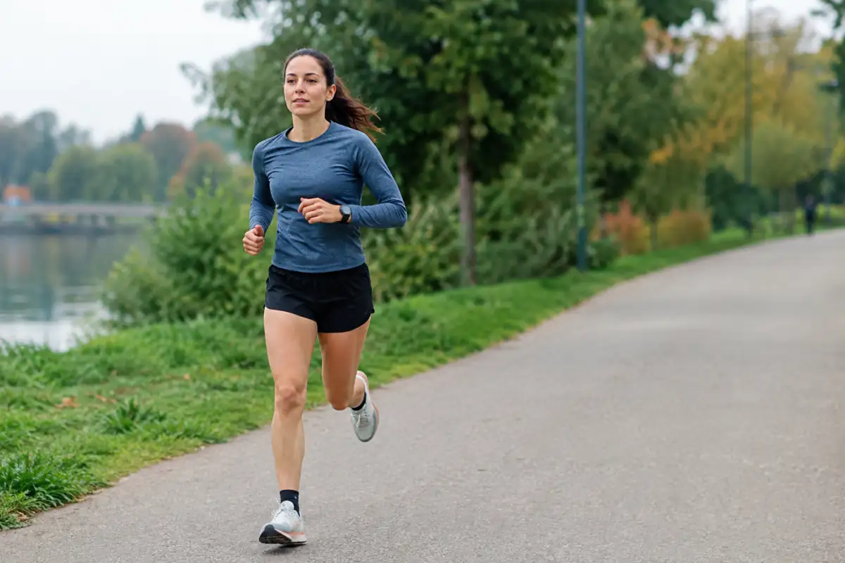 Coureur réalisant des fractions à allure contrôlée sur un chemin plat, montre au poignet et posture détendue pendant sa préparation au 10 km.