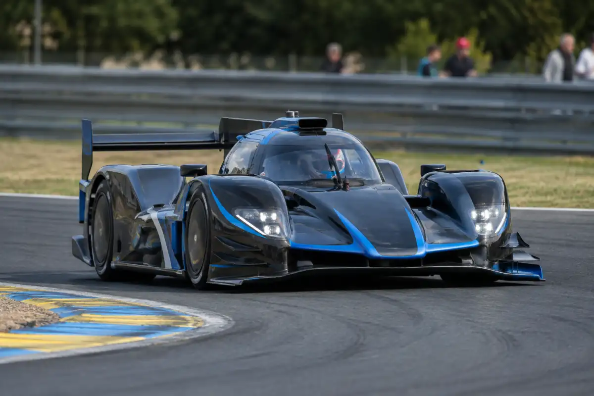 Prototype fermé en course sur circuit, roues carénées et aileron arrière, piloté au ras des vibreurs.