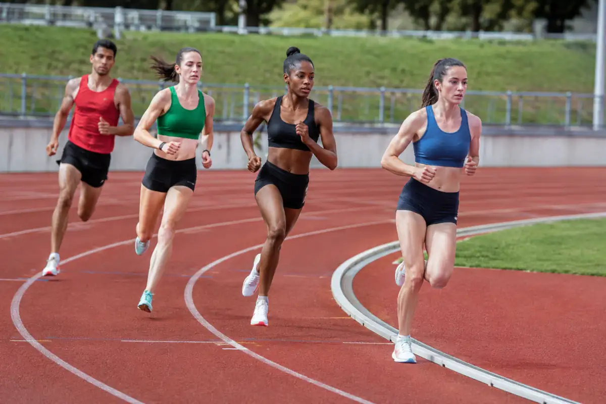 Coureurs de 800 m se rabattant vers la corde après la ligne de rabattement, sur une piste d’athlétisme extérieure.