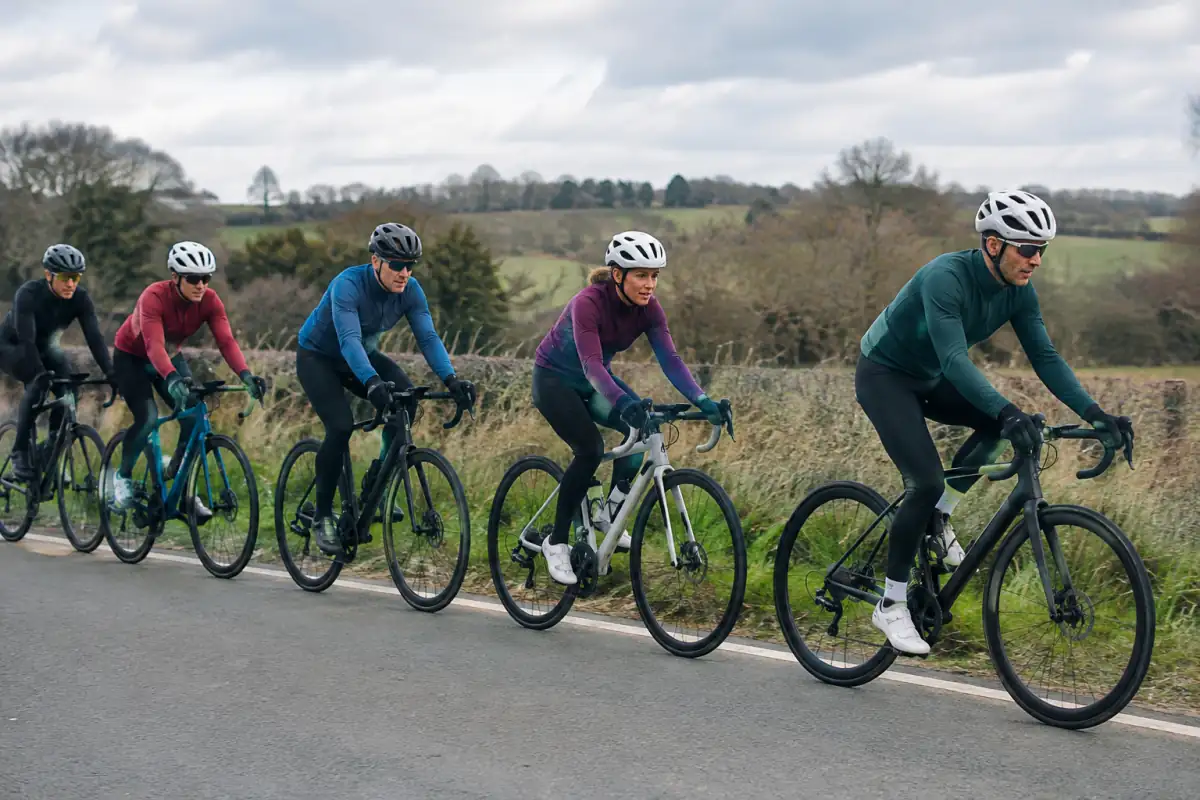 Cyclistes sur route en file décalée : un coureur passe le relais tandis que le groupe maintient des écarts réguliers.