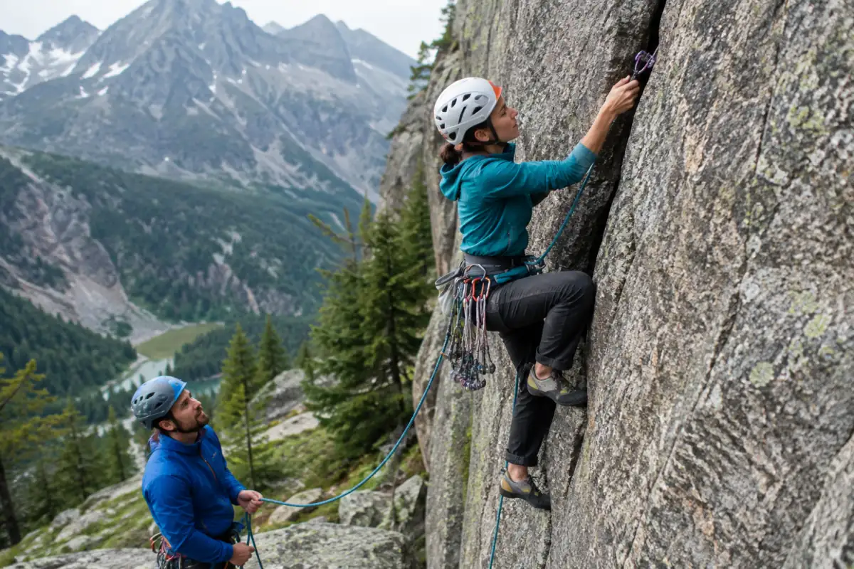 Un grimpeur pose un coinceur dans une fissure lors d’une ascension d’escalade en terrain d’aventure dans les Alpes.