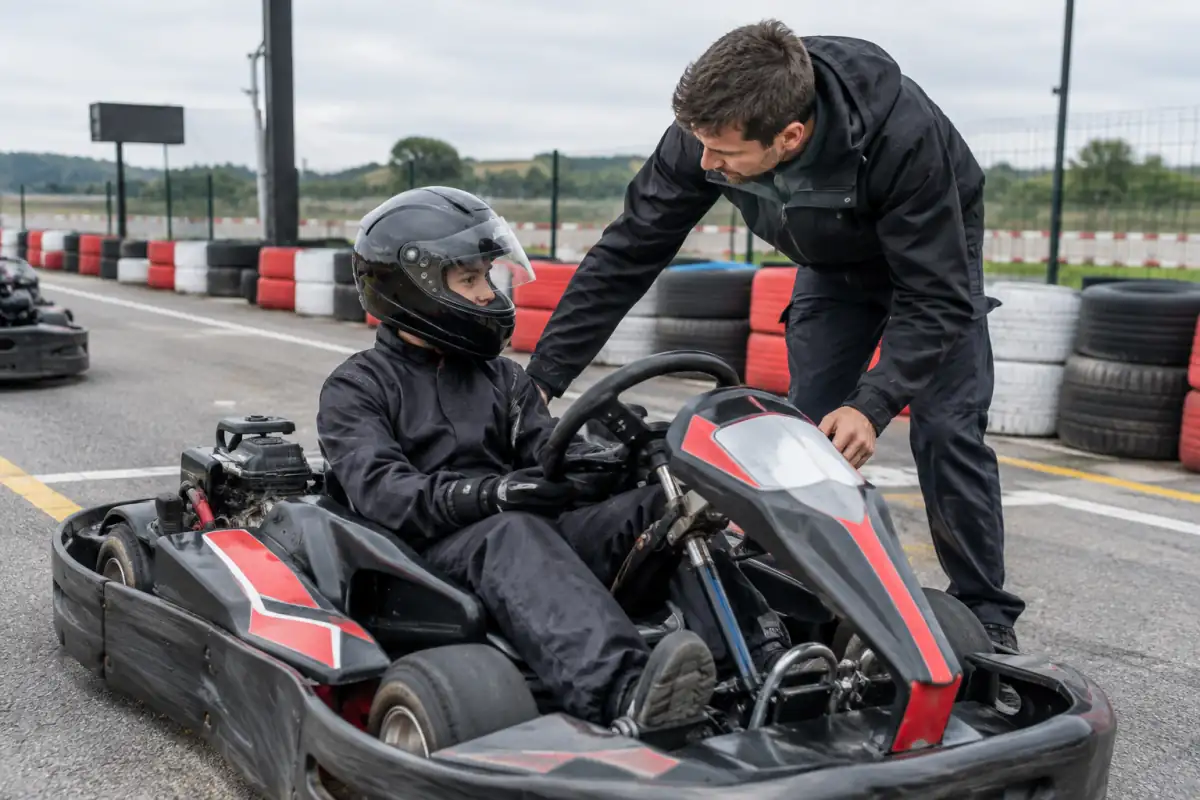 Un instructeur vérifie le casque et la position d’un débutant dans un kart de location avant sa première séance.