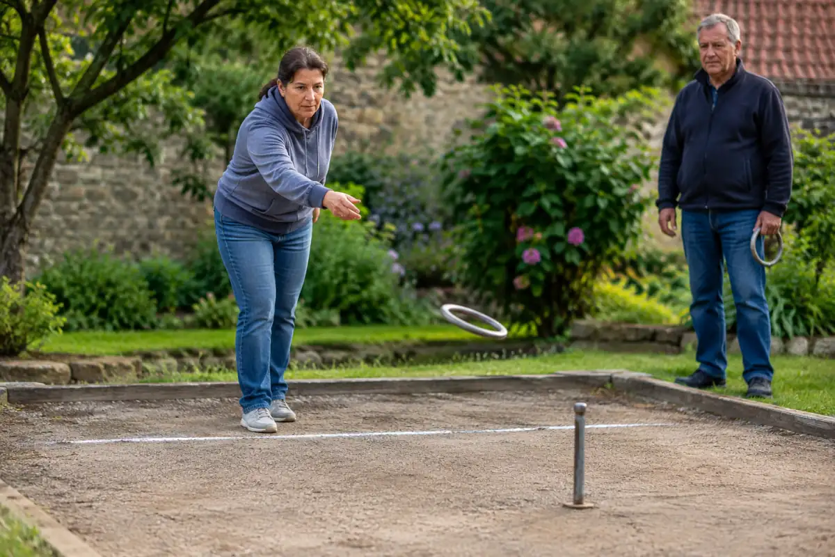 Un joueur lance un anneau vers un piquet sur une aire dégagée lors d’une partie de jeu des anneaux en extérieur.