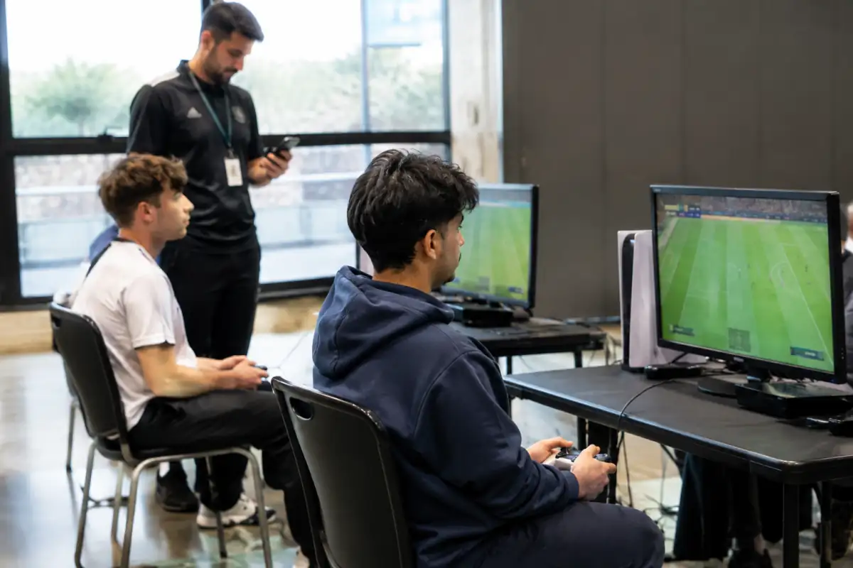 Deux joueurs d’e-football vérifient le score d’un match avec un organisateur après une rencontre de tournoi.