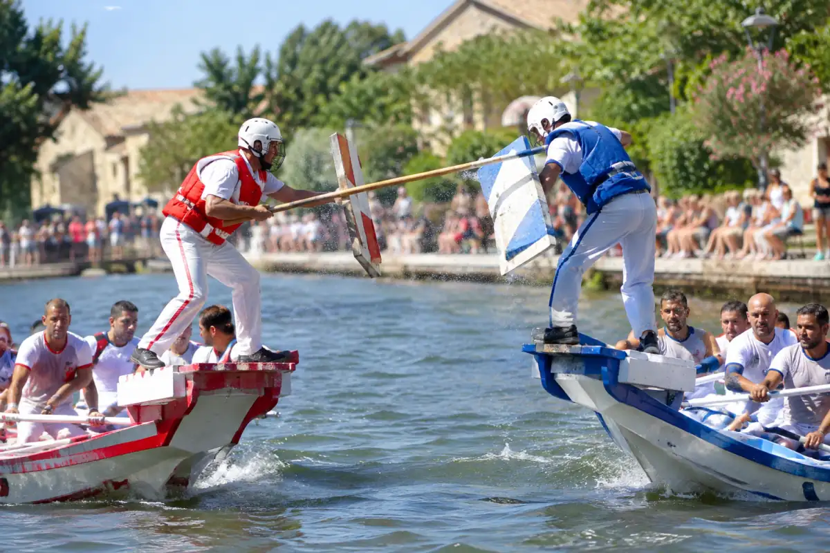 Deux jouteurs nautiques casqués s’affrontent à la lance sur des embarcations, au cours d’une compétition estivale en France.