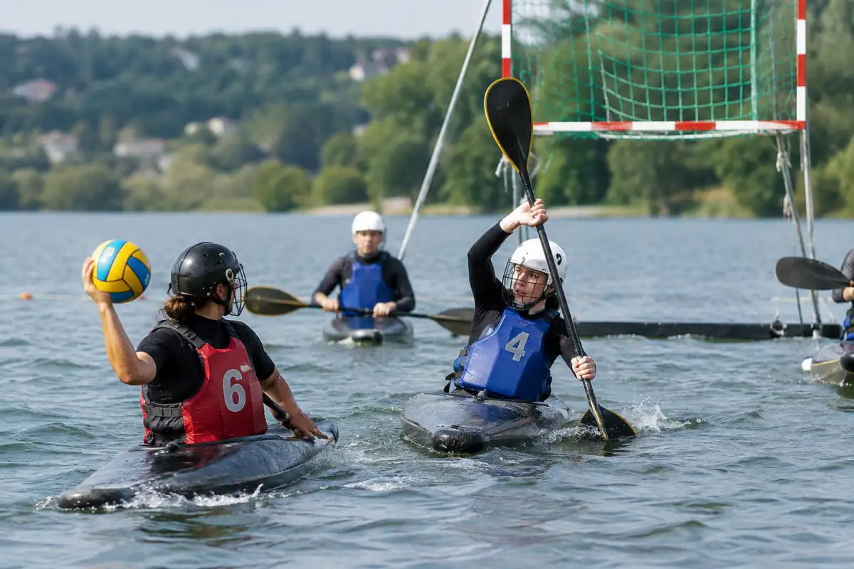 Match de kayak-polo sur un bassin : deux joueurs en kayak se disputent le ballon sous un but suspendu.