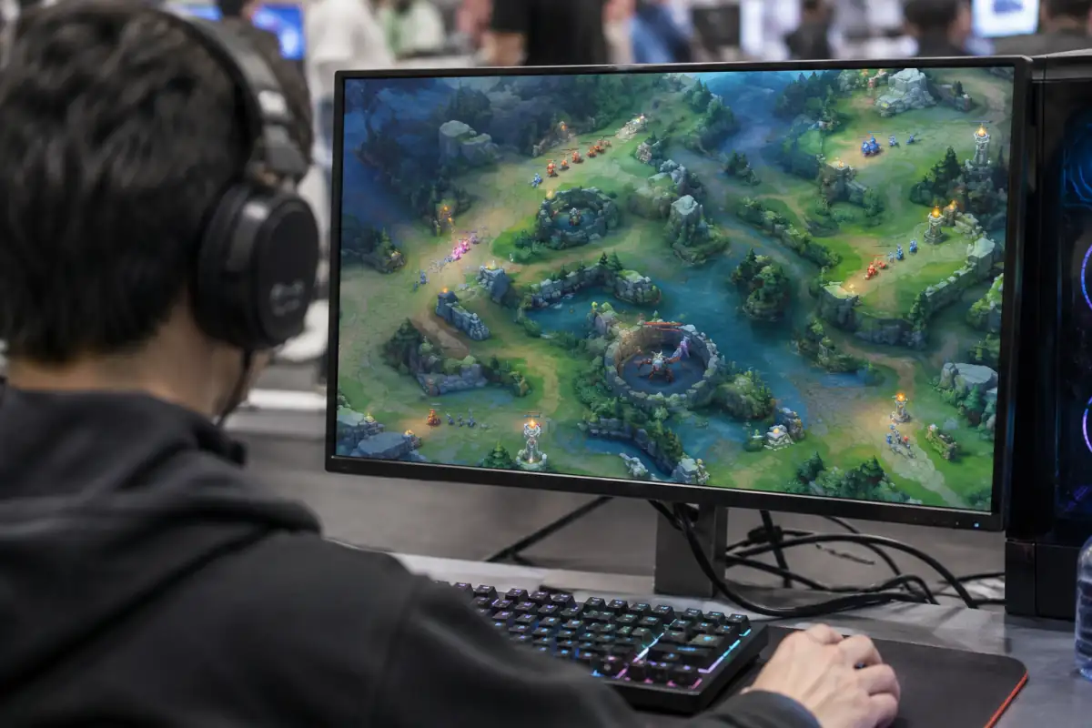 Joueur observant une carte de MOBA où des vagues d’unités avancent sur les voies vers les structures adverses.