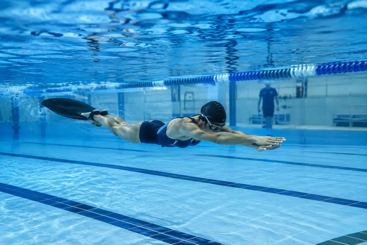 Nageur équipé d’une monopalme en course sous l’eau lors d’une épreuve de nage avec palmes en immersion en piscine.