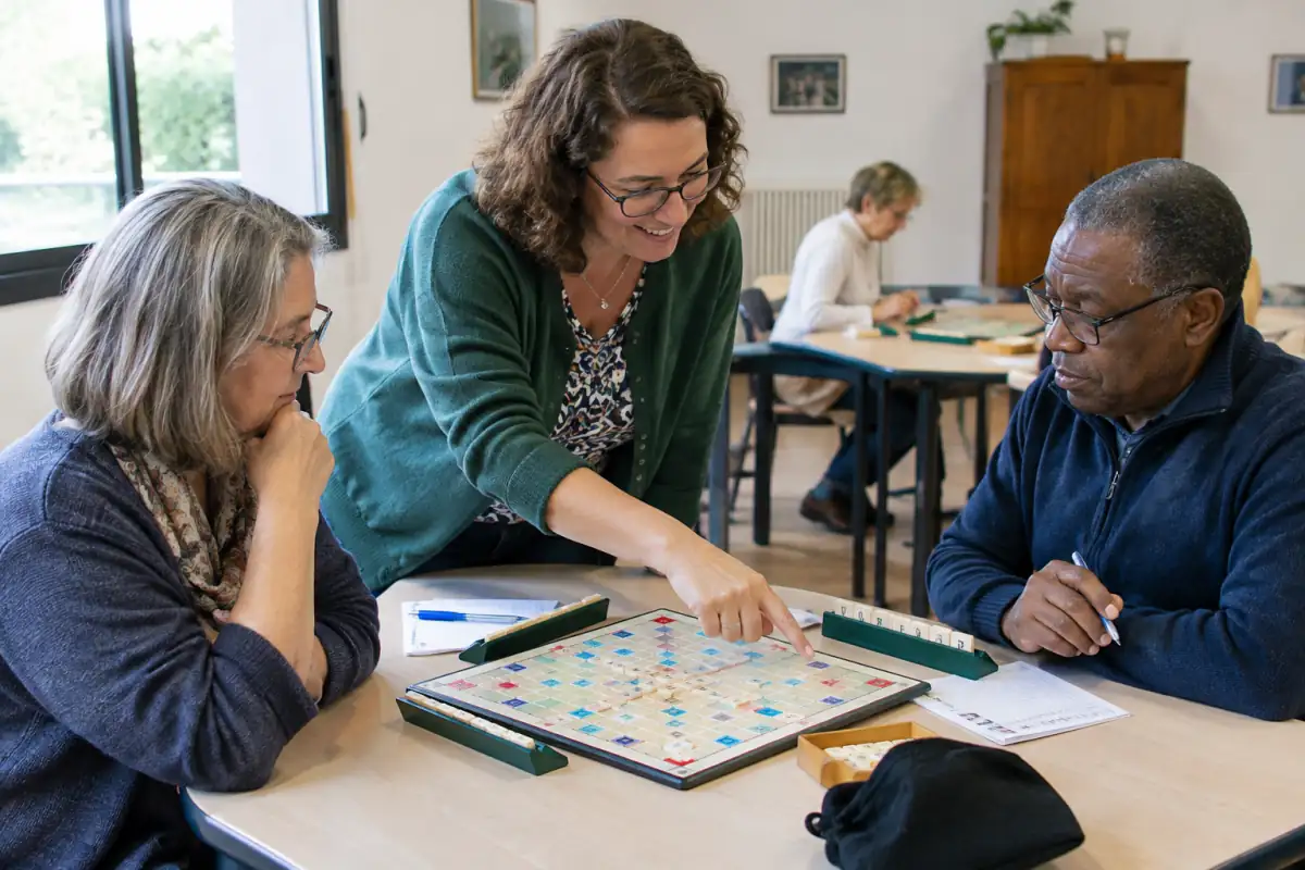 Des joueurs découvrent le Scrabble duplicate en club, avec grilles, chevalets et bulletins sous les explications d’un animateur.
