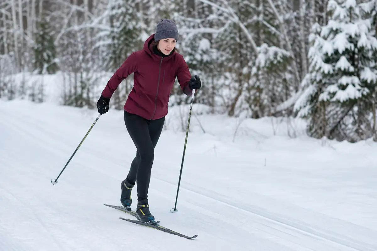 Débutant en ski de fond classique travaillant le transfert du poids sur une piste plate et préparée, à allure tranquille.